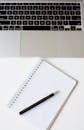 Pen on a Spiral Notebook Beside a Laptop Keyboard