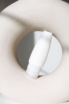 Stylish minimalist still life shot of a cosmetic bottle with creative geometric composition.