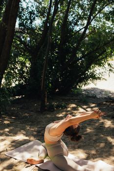 Woman performing yoga in a serene outdoor setting, promoting wellness and mindfulness.
