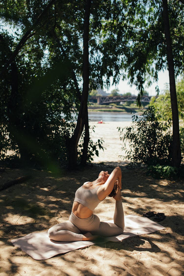 A Flexible Woman Doing Yoga Near Trees