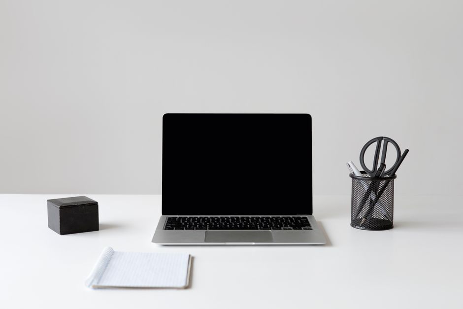5 Essential Desk Options for Small Rooms: Workspace Solutions for Maximized Productivity and Minimal Clutter Compact work desk in a small home office setup with a person working on a laptop and notebook