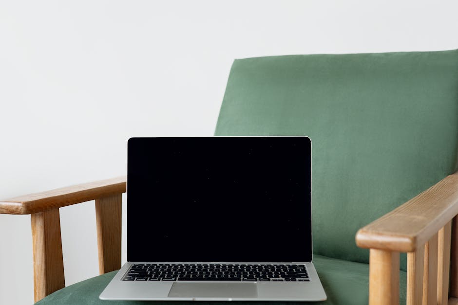 A sleek laptop sits on a stylish green chair, perfect for tech mockups and design showcase.