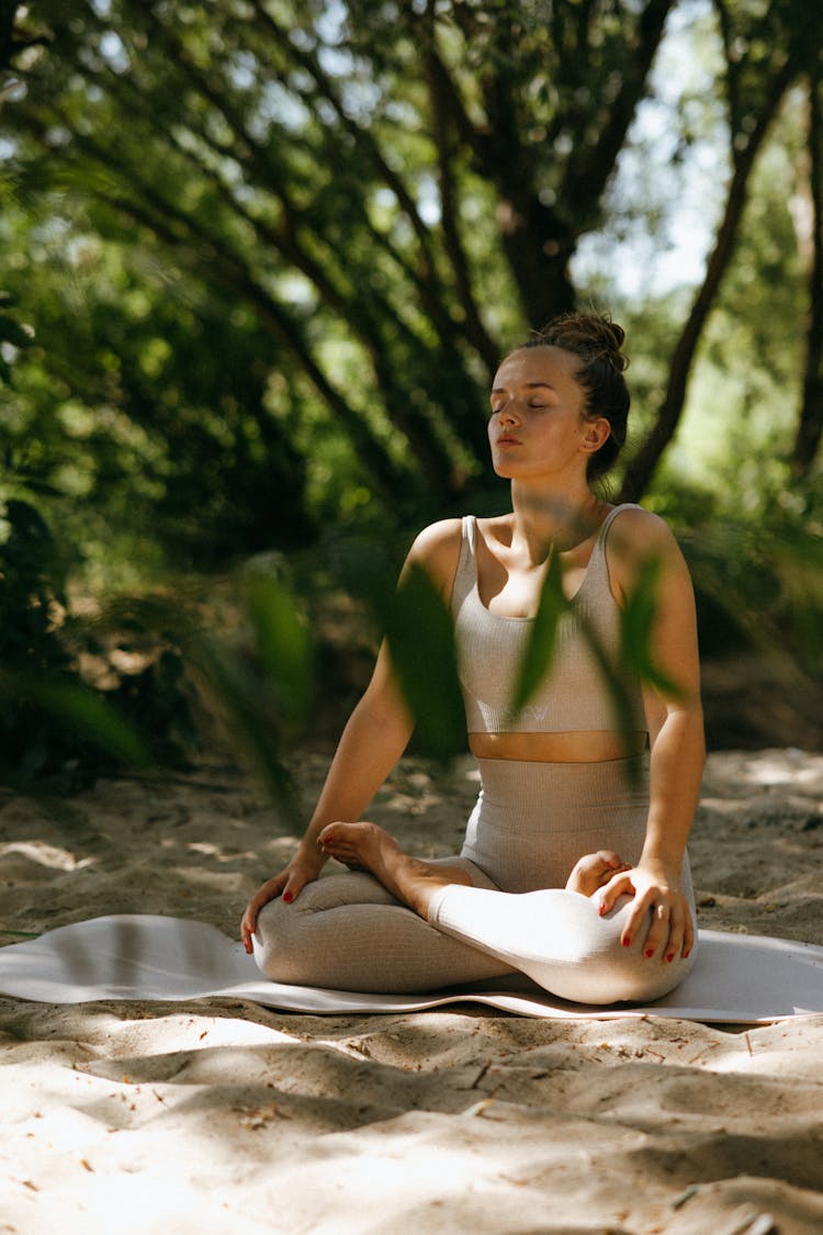 Photo Of A Woman Meditating On A Yoga Mat Outdoors