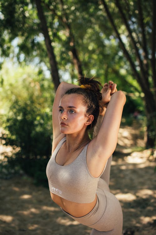 Close-Up Photo of a Woman in Beige Activewear Doing a Yoga Pose