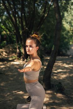 Woman practicing yoga outdoors in a serene forest setting. Embracing healthy lifestyle and mindfulness.