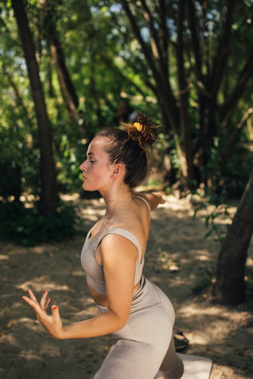 A Woman Working Out Near the Green Trees