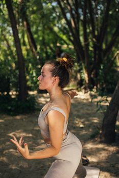 A woman performing yoga poses outdoors in a peaceful forest setting, embodying mindfulness and health.