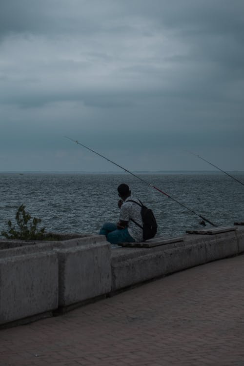 Photos gratuites de bord de mer, canne à pêche, être assis