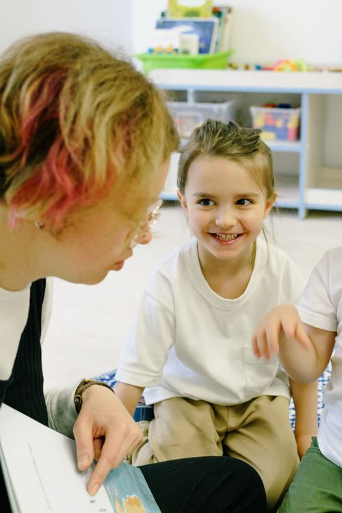Free A teacher reading with young children in a kindergarten classroom setting. Stock Photo