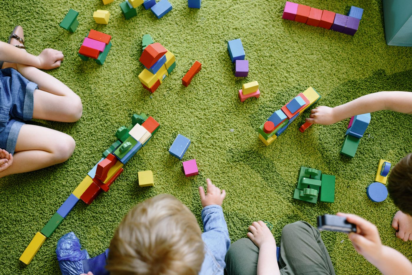 Children playing with colorful wooden blocks in a classroom
