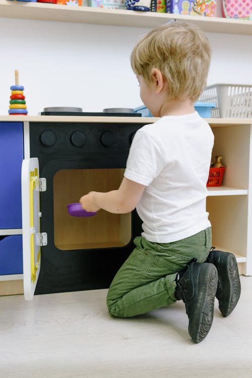 A Boy Playing with Wooden Toy Cabinet