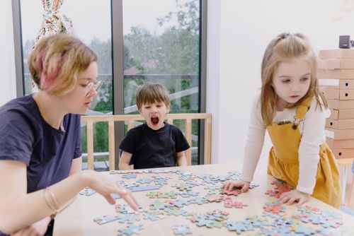Free Family engaging in puzzle activity indoors, highlighting creativity and togetherness. Stock Photo