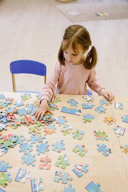 A Girl Looking at the Puzzle on the Table