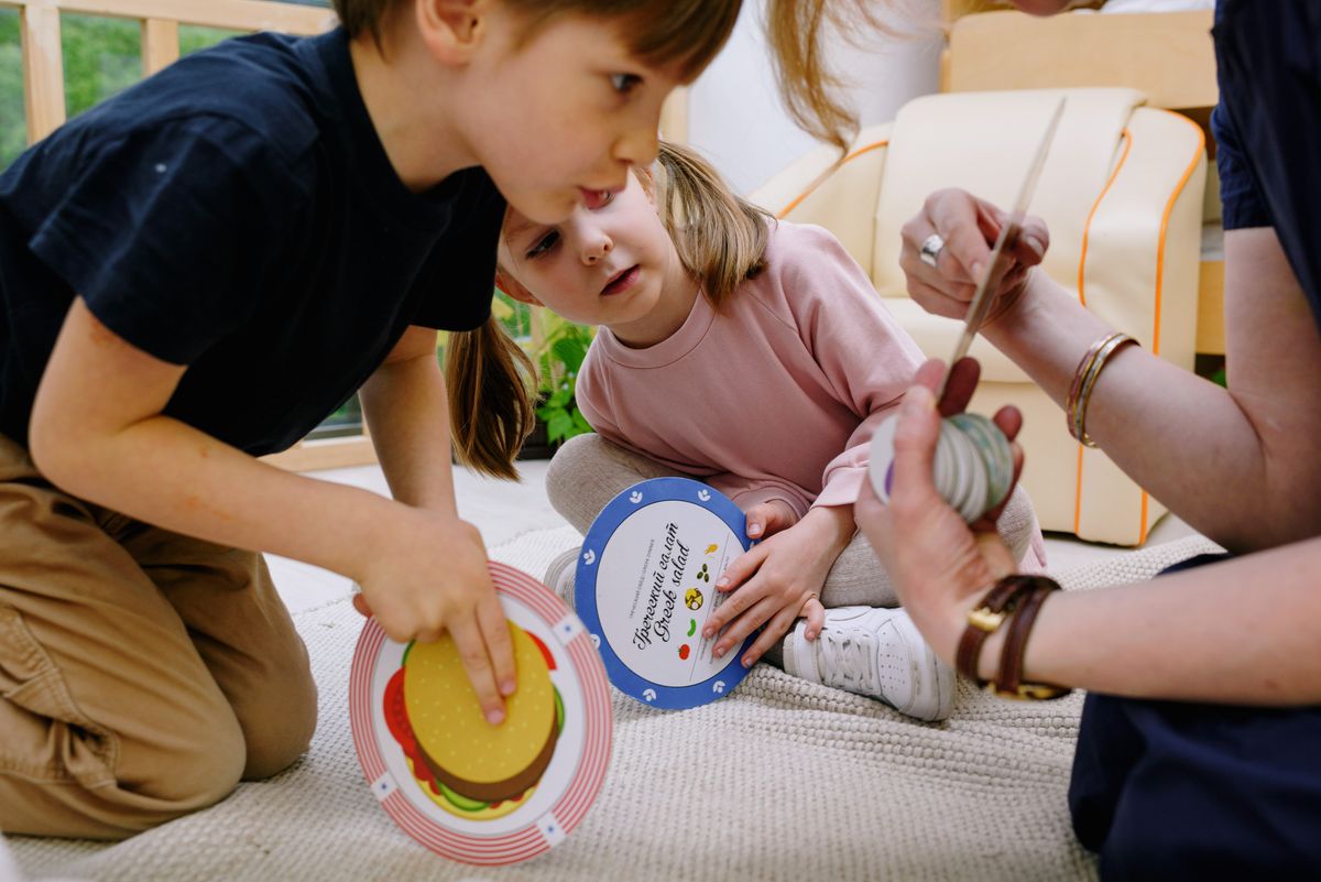 Children playing with educational toys alongside a supportive adult