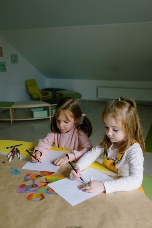 Two Girls Drawing on Paper