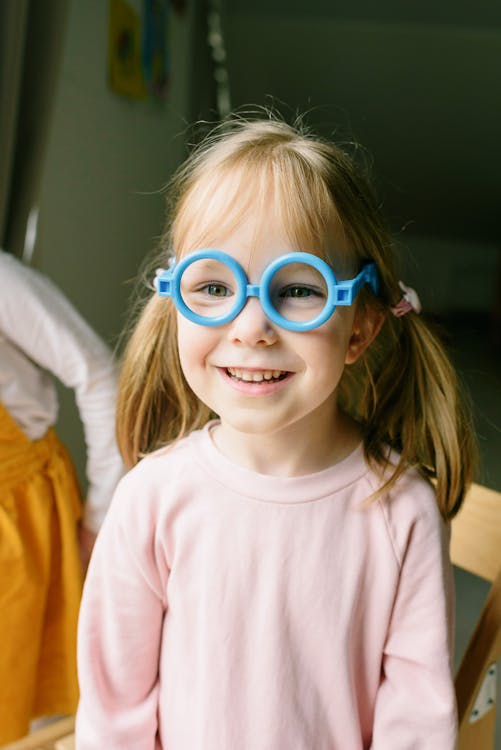Girl in Pink Shirt Wearing Blue Framed Eyeglasses