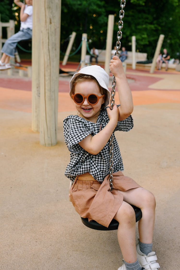 Little Girl Swinging And Smiling 