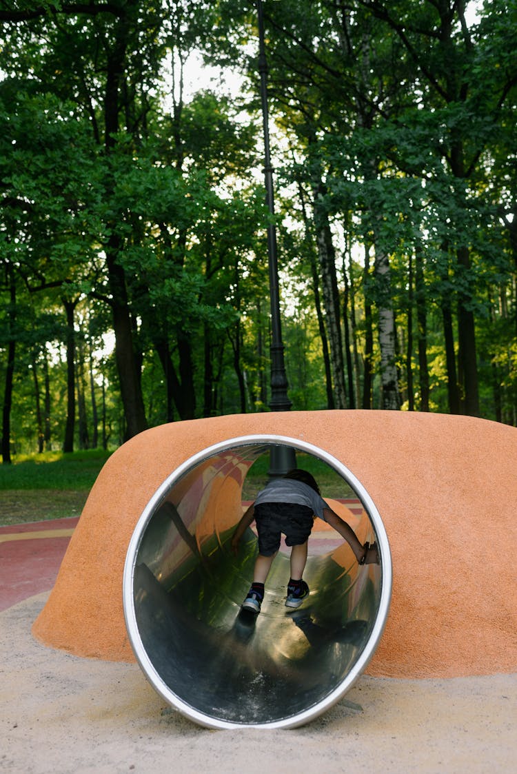 Child Crawling Through A Tube On A Playground