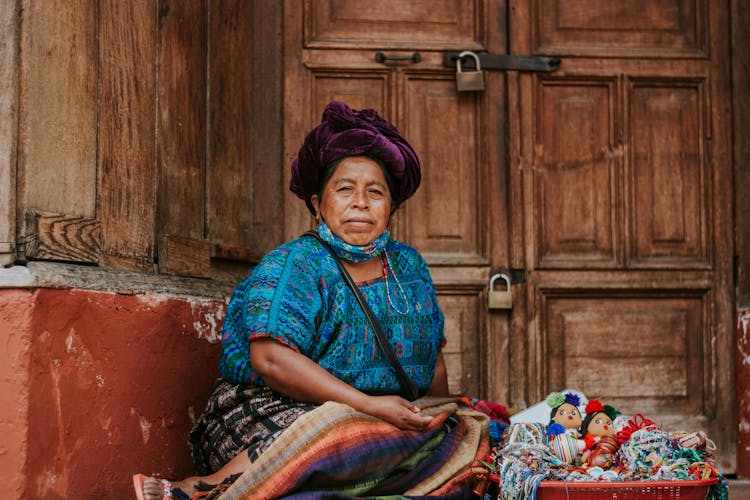 Woman Sitting With Dolls Near Door