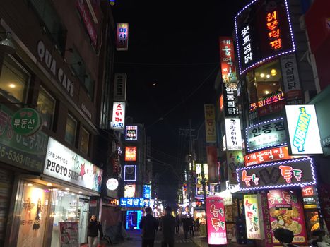 Explore the bustling streets of Changcheon-dong, Seoul filled with neon lights and lively nightlife.
