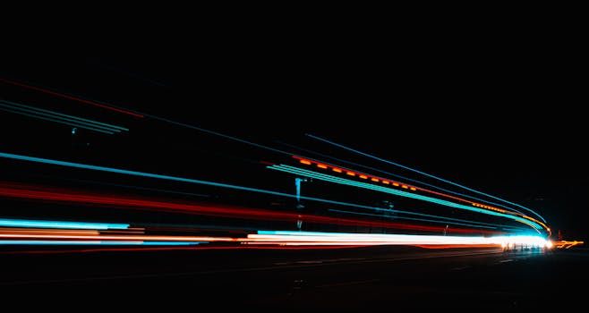Long exposure photography capturing vibrant light streaks on a highway at night.