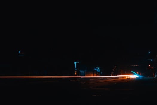 Dynamic long exposure of light streaks in a city at night, capturing movement and color contrast.
