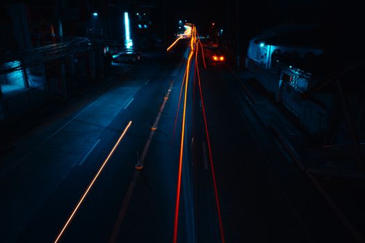 Long exposure capture of a highway at night, showcasing vibrant light trails and urban ambiance.