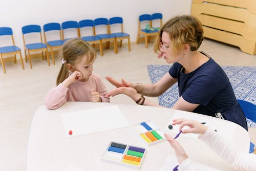 A Teacher Molding Clay in front of the Student