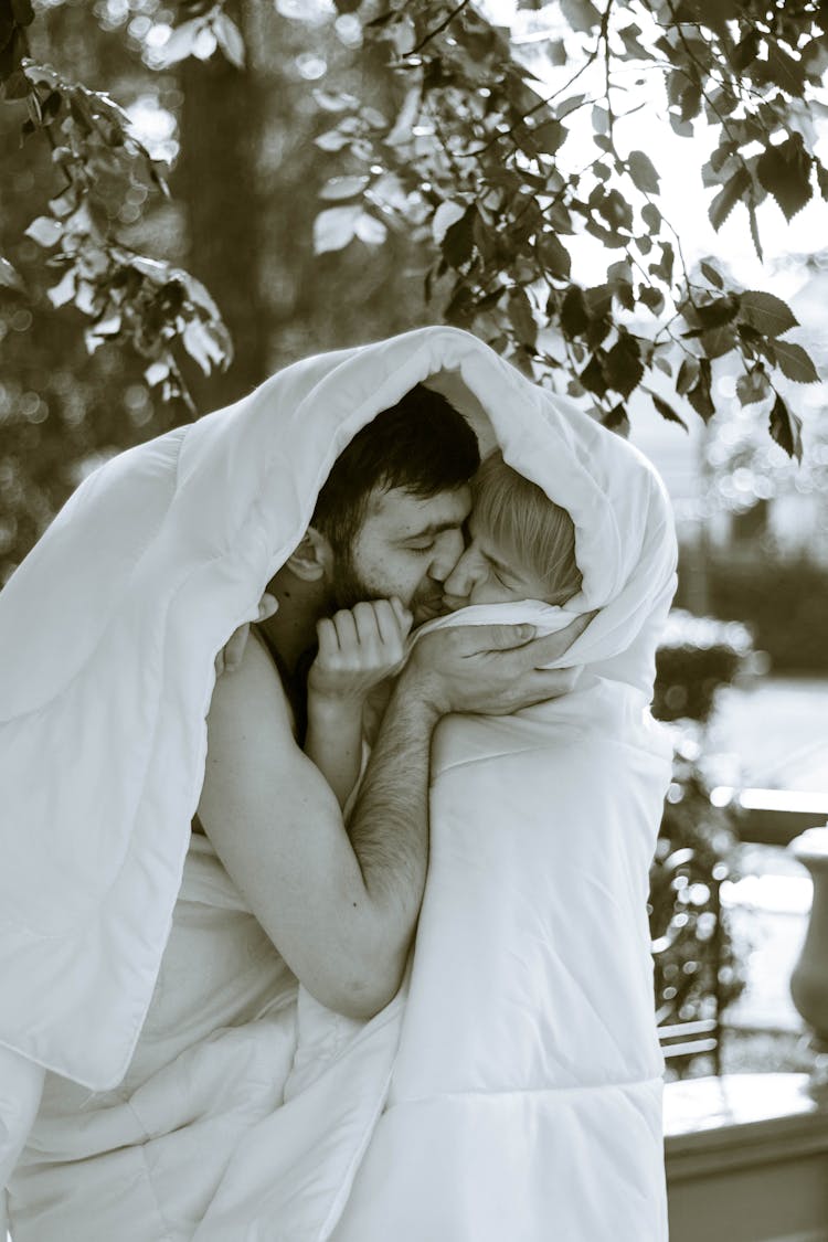 Couple Wrapped With White Blanket Kissing