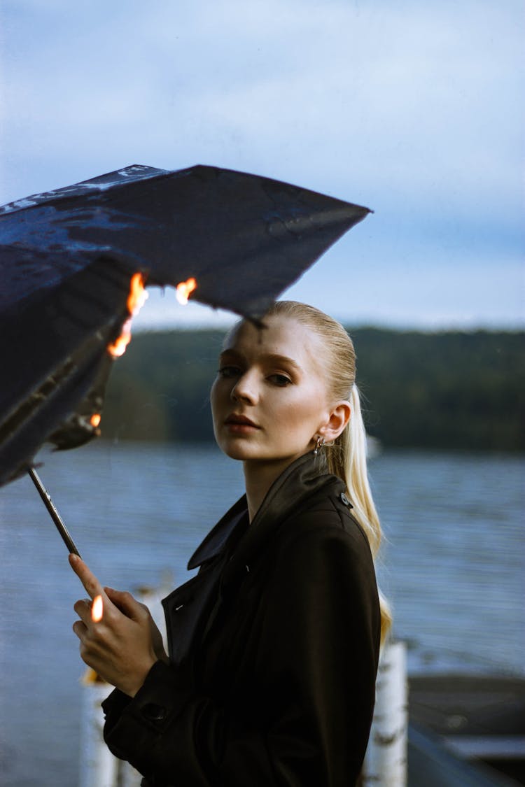 Woman In Black Coat Holding Umbrella On Fire