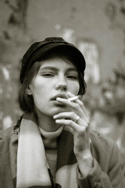 Grayscale Photo of Woman Smoking Cigarette 