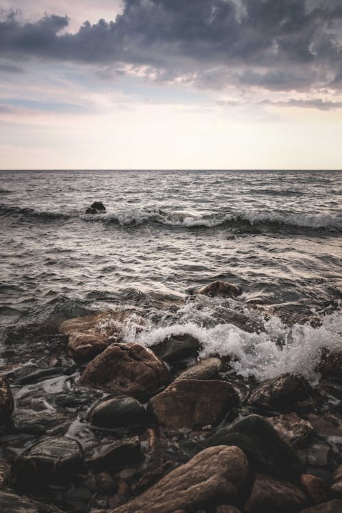 Ocean Waves Crashing on Brown Rocks