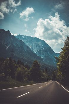 A picturesque mountain road in Austria with stunning alpine scenery and blue sky.