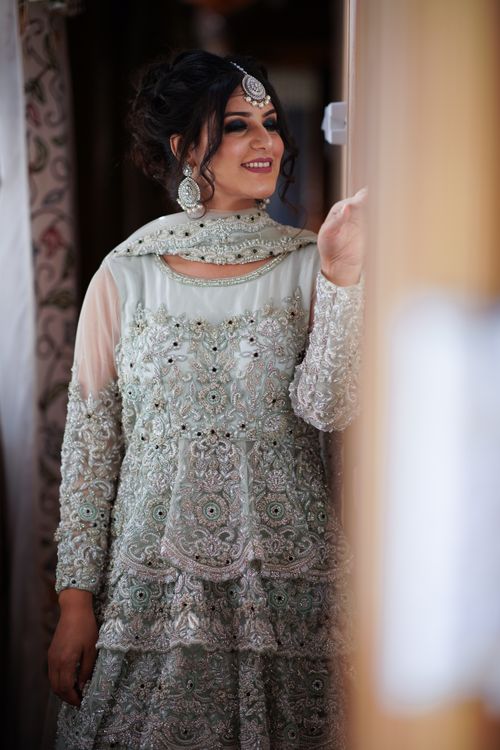 Free Beautiful Indian bride in ornate traditional dress smiling indoors, showcasing elegance and style. Stock Photo