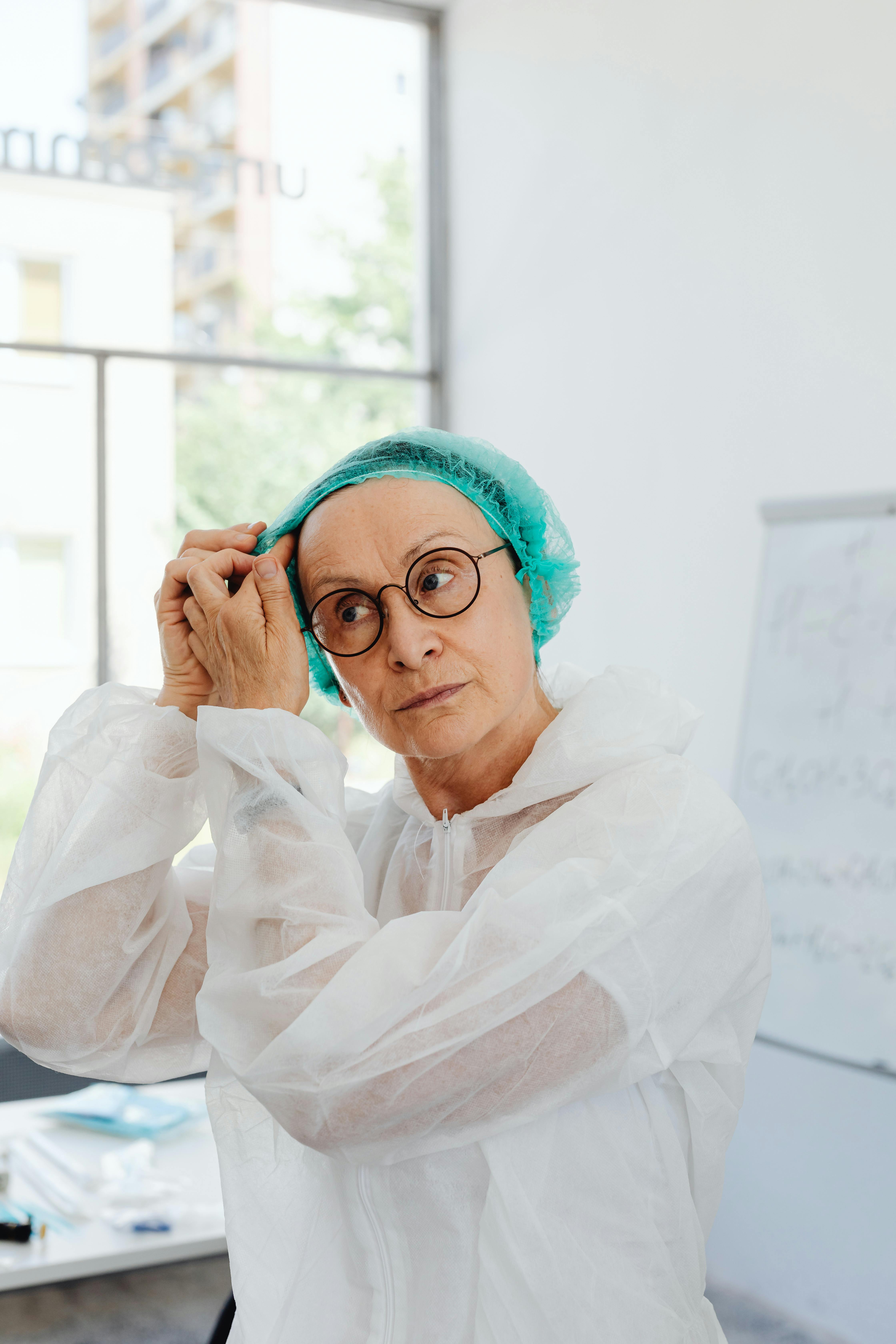 a woman wearing hair net and scrub suit