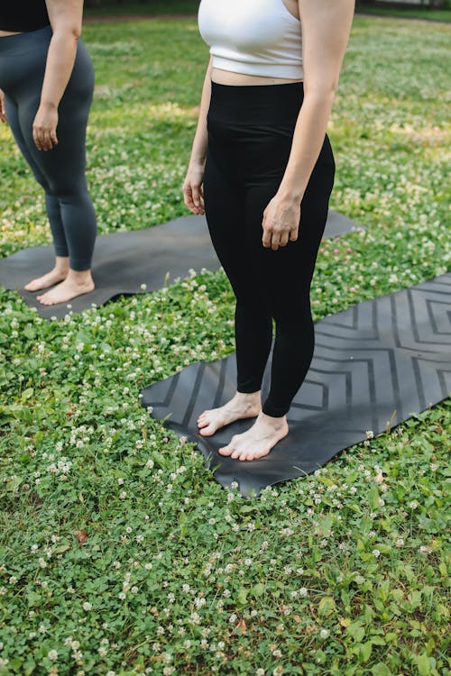 Women Standing on Black Yoga Mat