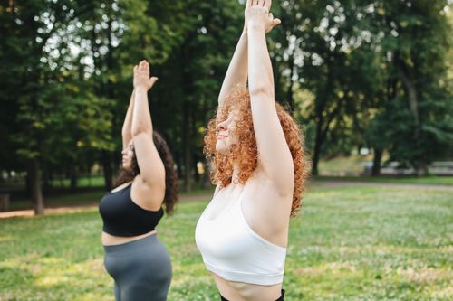 Free Two women enjoying a yoga session in a lush green park, embracing a healthy lifestyle. Stock Photo