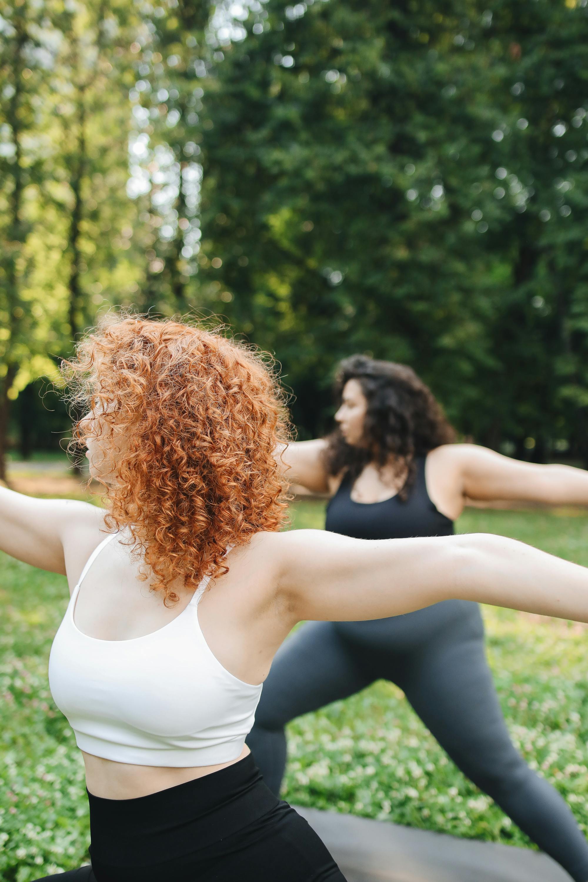 two women doing yoga outdoors