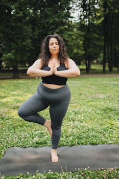 Confident plus size woman practicing yoga outdoors on a sunny day.