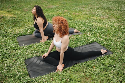 Free Women on Yoga Mats on Green Grass Stock Photo