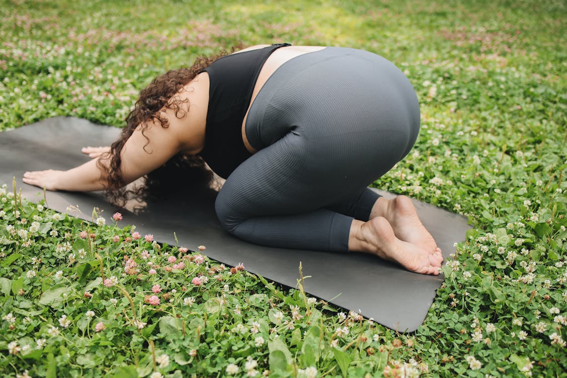 Woman in Black Brassier and Gray Leggings Doing Yoga
