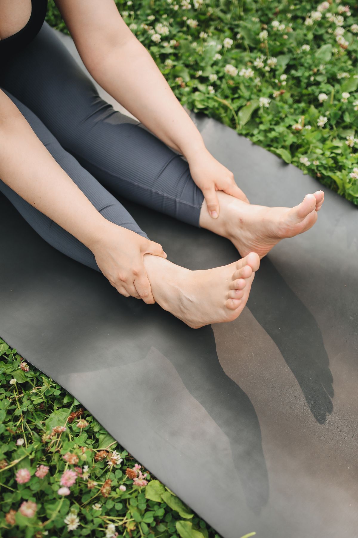 A person stretching on a yoga mat outdoors