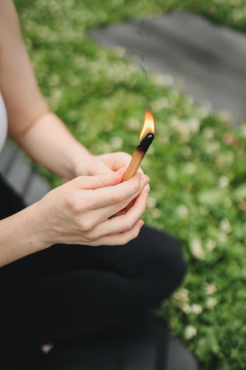 Person Holding a Burning Palo Santo