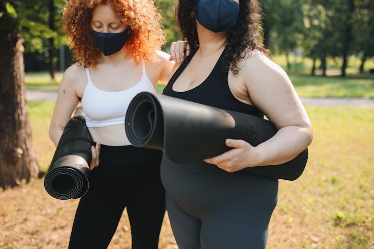 Girls Holding Rolled Yoga Mats