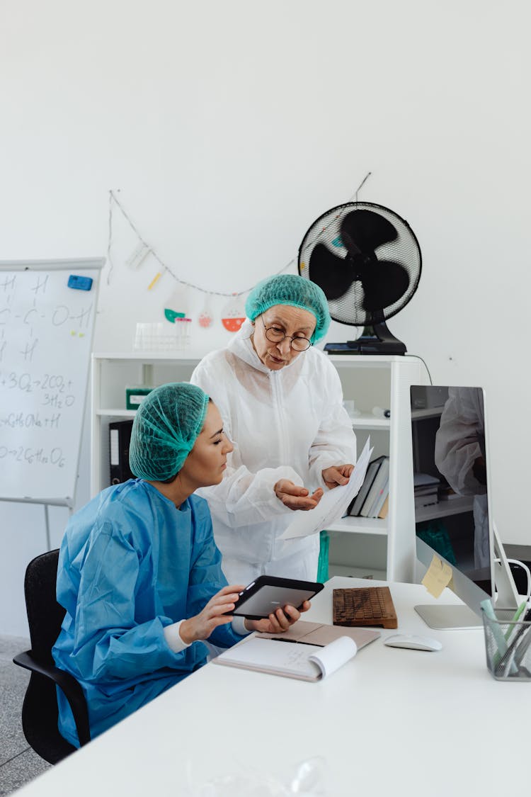 Medical Professionals Looking At Paperwork And A Tablet