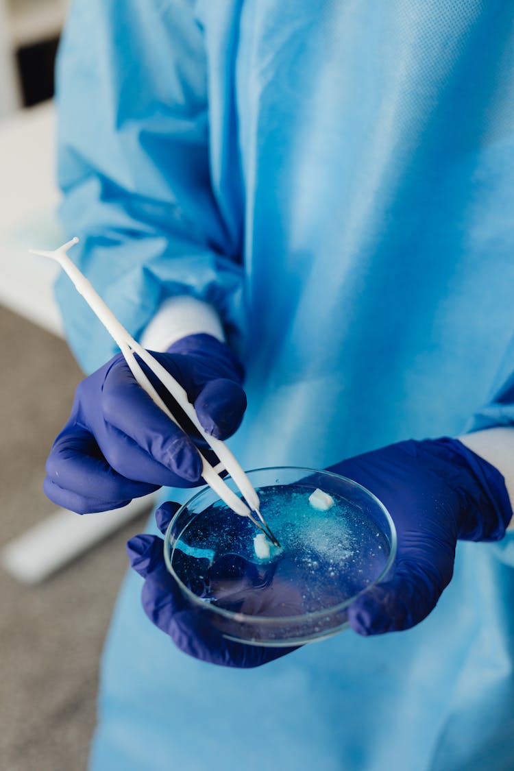 Person Dissolving Tablets On A Petri Dish
