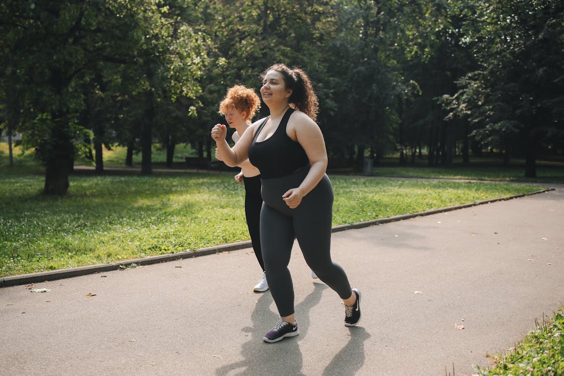 Fotografía mujer corriendo en un parque con ropa de jogging