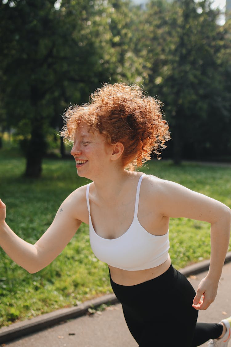 Woman In White Sport Bra Running At The Park 