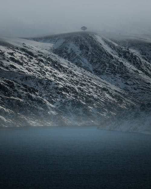 Snow Covered Mountain Near Body of Water