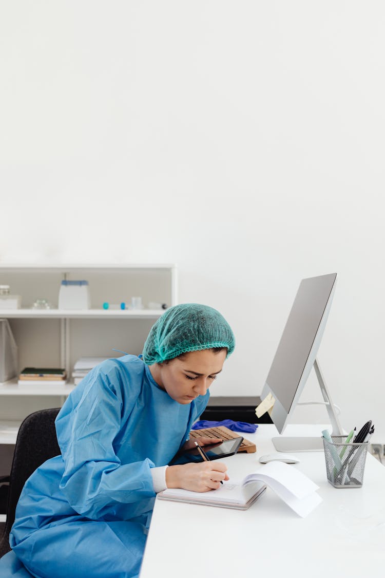 Researcher Writing On A Notepad